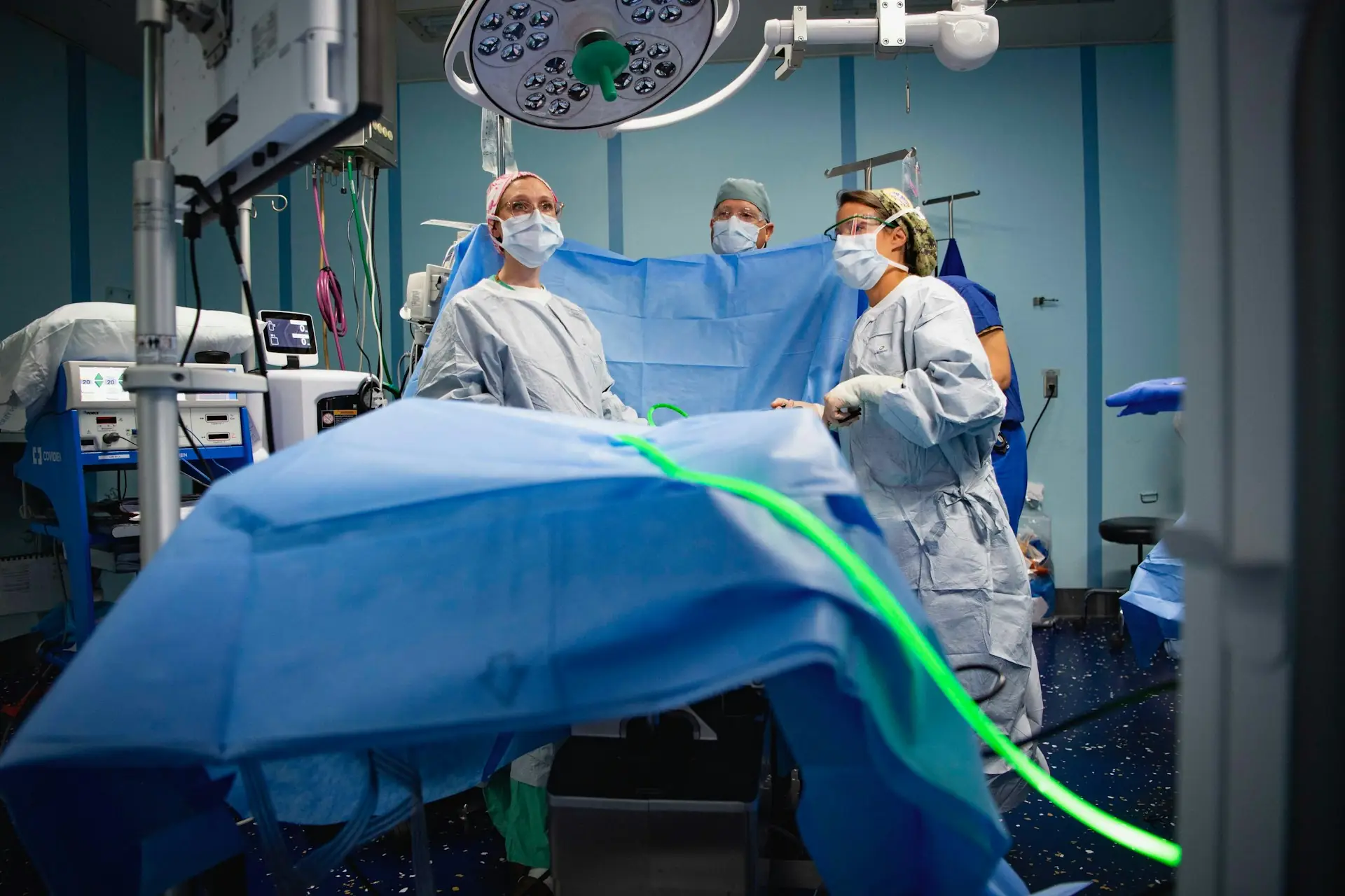 Surgical team in sterile gowns, caps and masks in an operating room