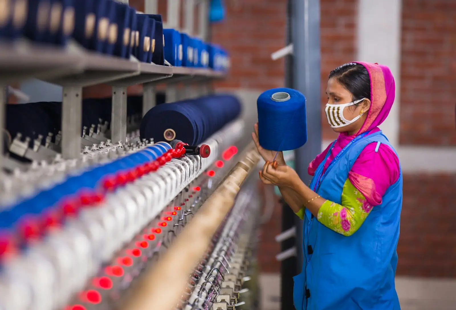 Operator working with blue yarn on a knitting machine